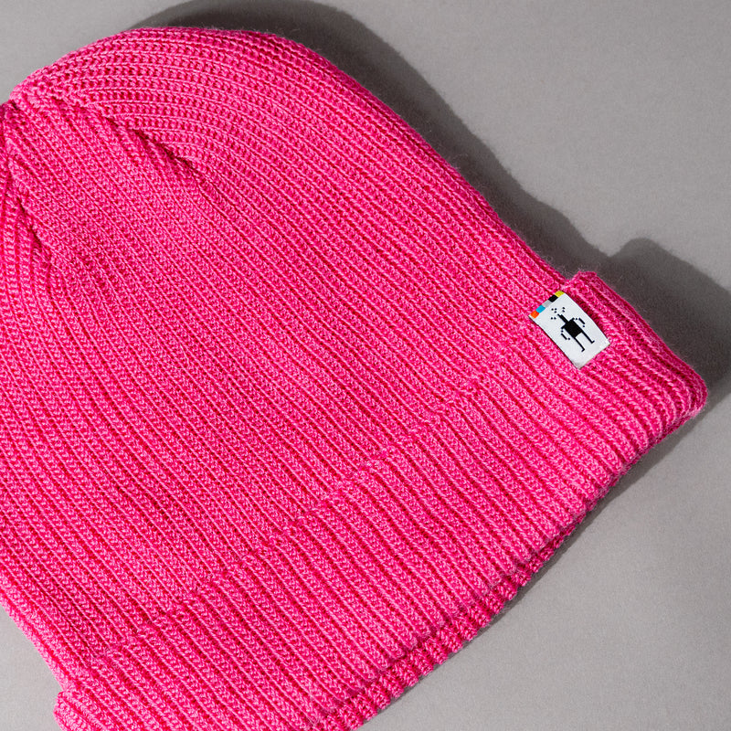 Woven detail view of The Smartwool Beanie in Pink Merino Wool, a unisex woven beanie with Smartwool logo patch and fold-up rim.