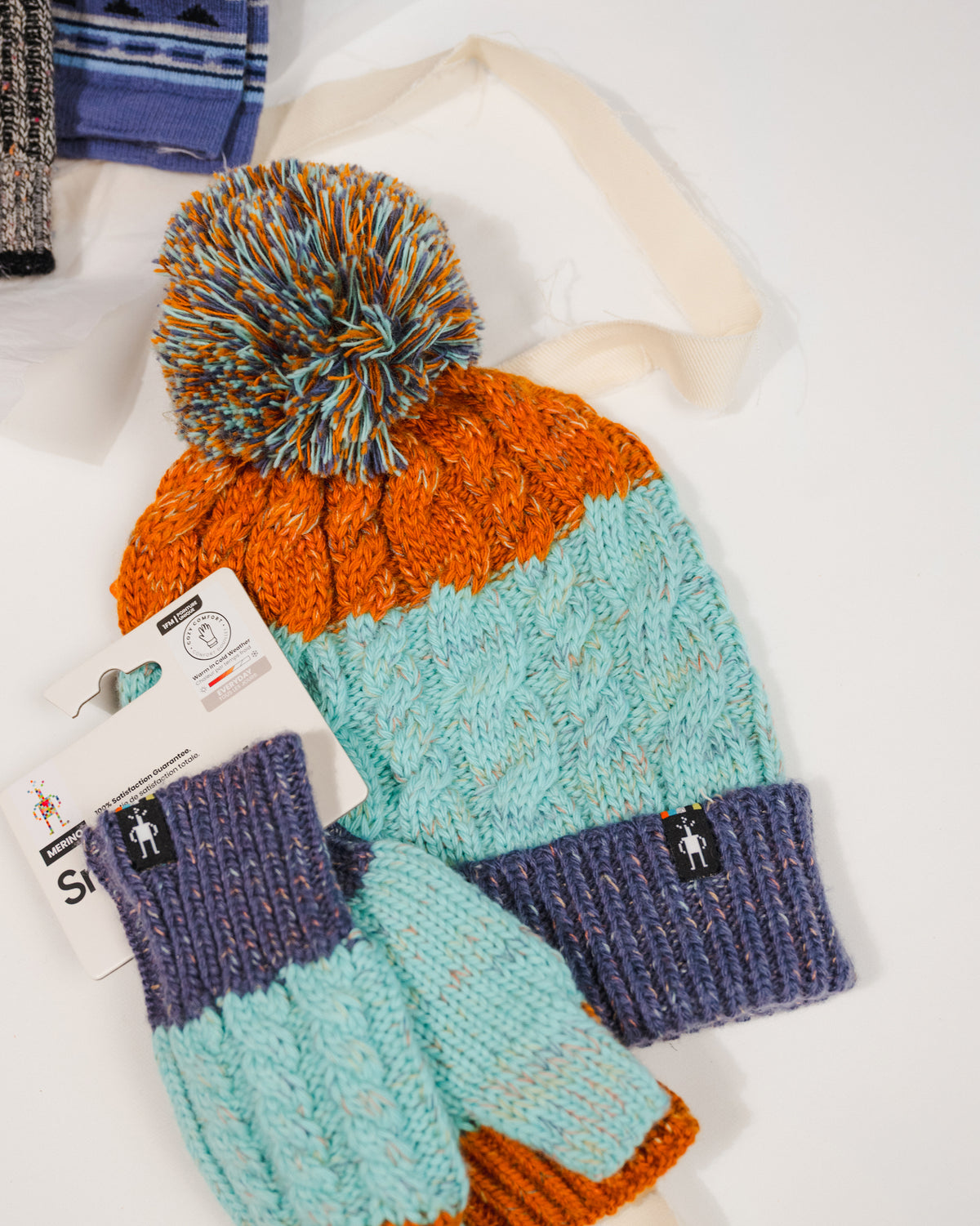 Front view of Smartwool Istro Retro Beanie showing knit texture and folded cuff and matching fingerless gloves