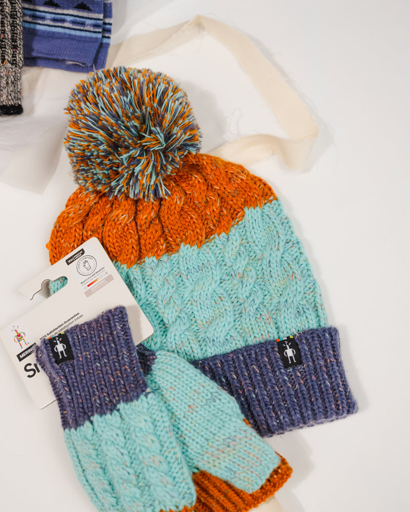 Front view of Smartwool Istro Retro Beanie showing knit texture and folded cuff and matching fingerless gloves