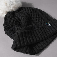 Detail of the soft knit of the Women's Smartwool Lodge Girl Soft Merino Knit Beanie with Faux Fur Pom in Black and Gray