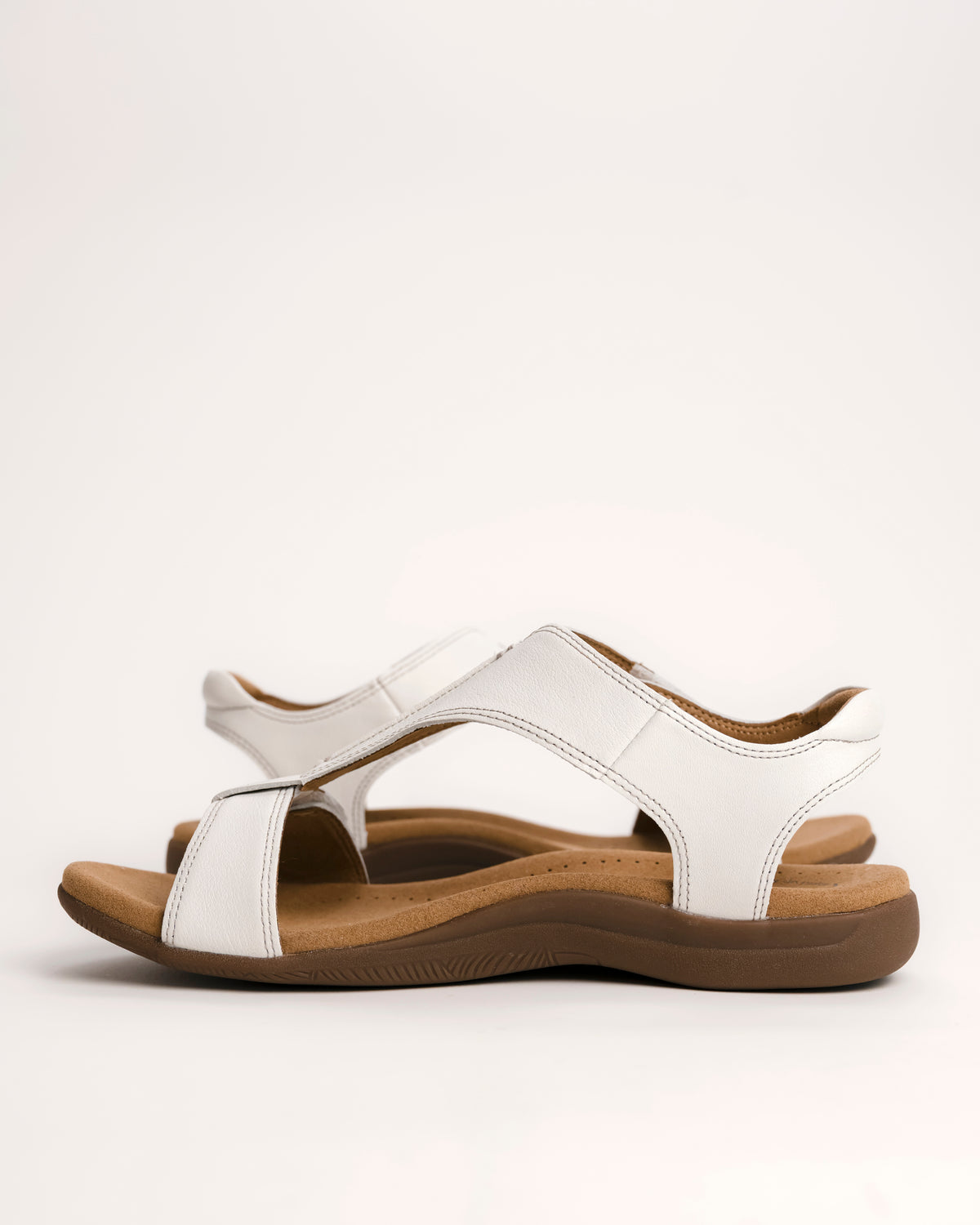 Women's Taos sandals. The Show comfort sandal features a premium white leather upper, adjustable straps, and a contoured cushioned footbed with arch support for all-day wear.