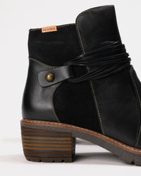 Close-up of the 2-inch heel and stitched shaft contour and metal rivet.