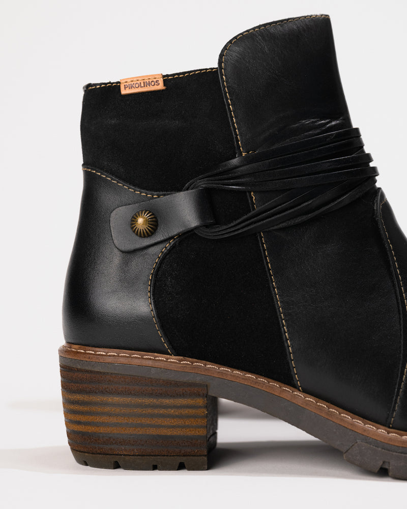 Close-up of the 2-inch heel and stitched shaft contour and metal rivet.