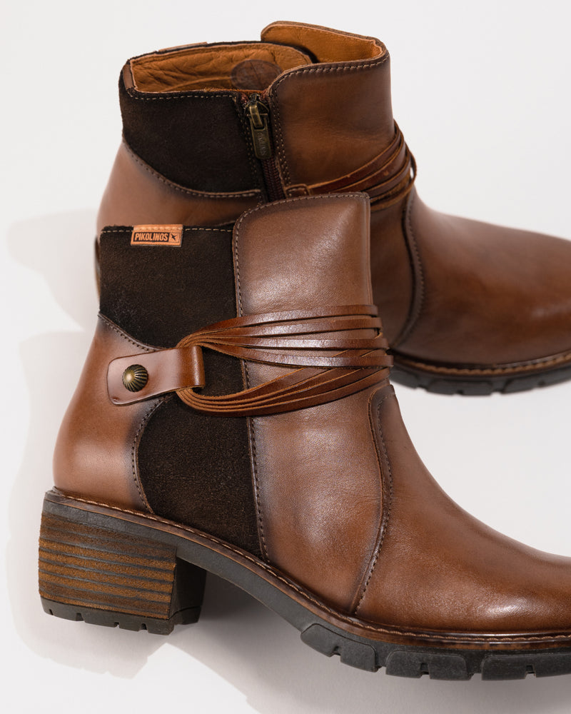 Close-up of the 2-inch heel, lace and rivet detail, and stitched shaft contour.