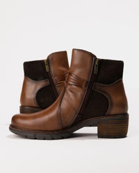Side shot displaying the outer ankle, zipper easy-on design, and curved leather panels.