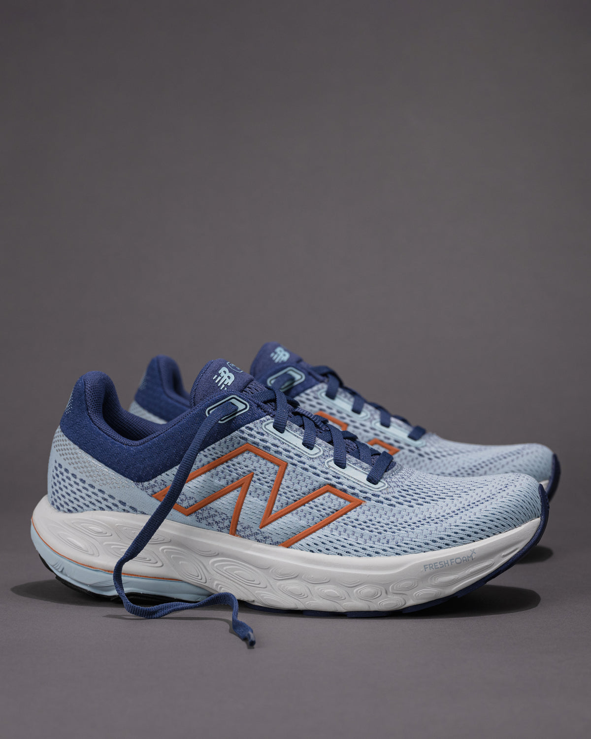 Pair of blue running shoes with orange accents on a gray background Women's New Balance Fresh Foam X 860 v14 Stability Shoe in Frost