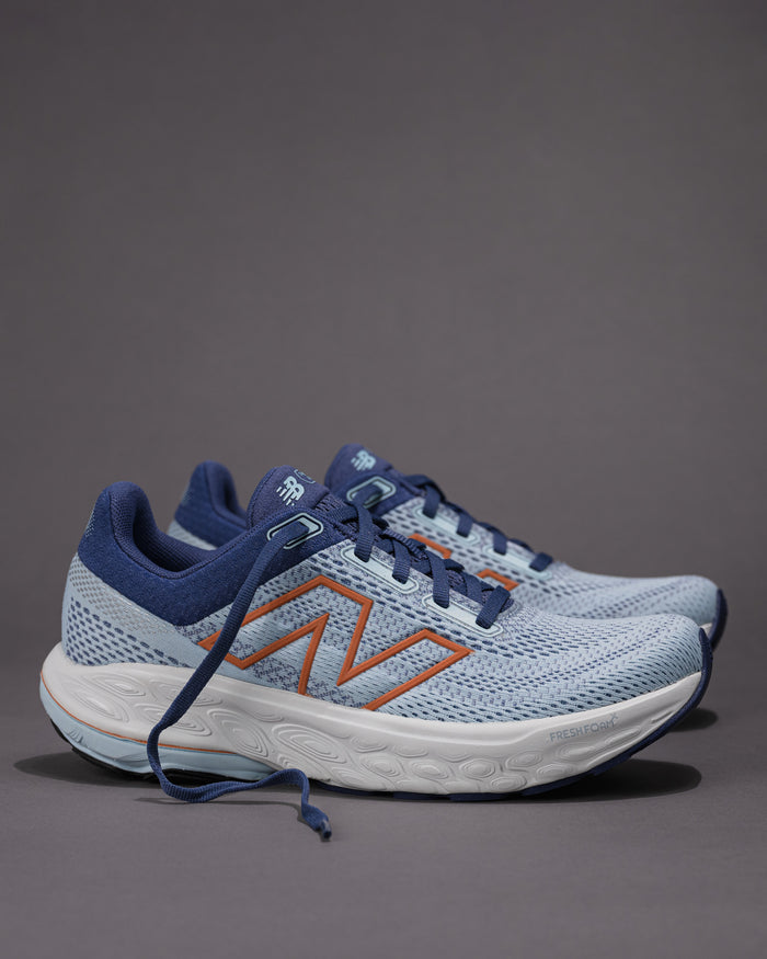Pair of blue running shoes with orange accents on a gray background Women's New Balance Fresh Foam X 860 v14 Stability Shoe in Frost
