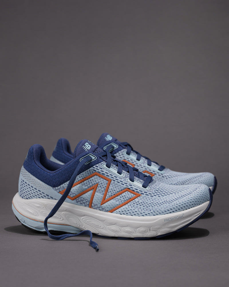 Pair of blue running shoes with orange accents on a gray background Women's New Balance Fresh Foam X 860 v14 Stability Shoe in Frost