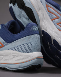 Close-up of blue and gray running shoes with '860' branding on a gray background - Women's New Balance Fresh Foam X 860 v14 Stability Shoe in Frost