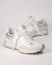 Street-style flat lay of New Balance 327 retro sneakers in Silver metallic finish