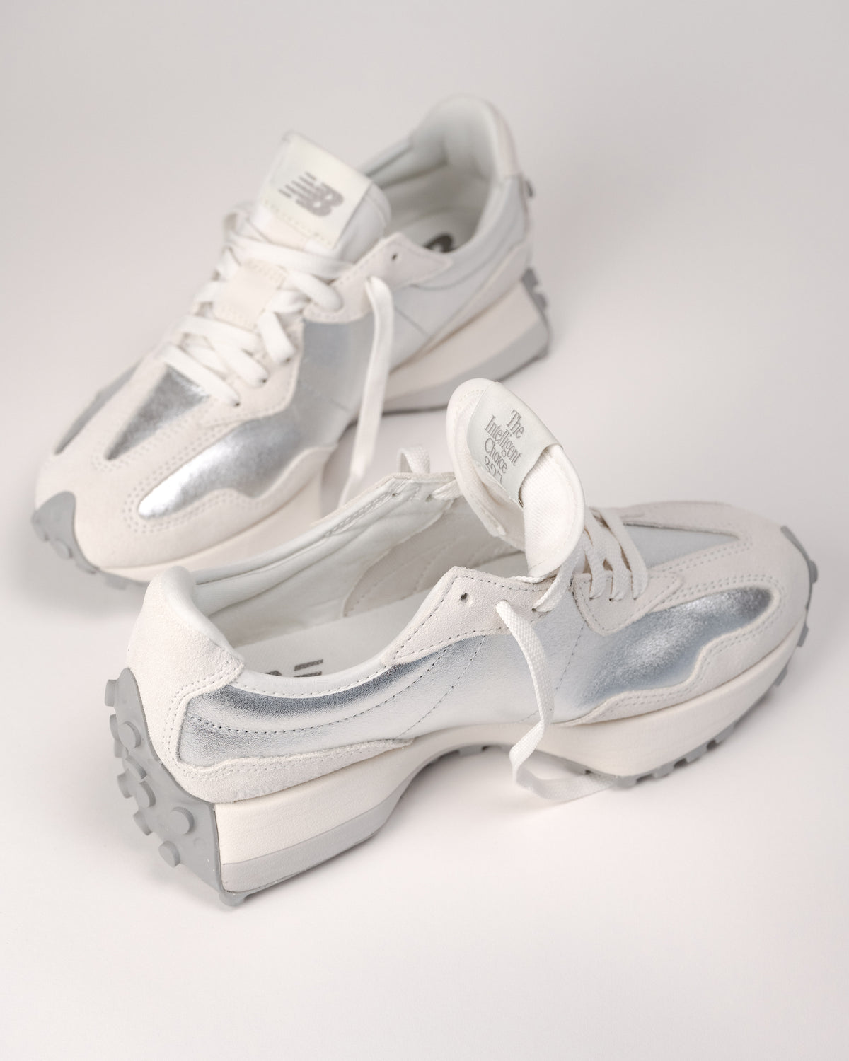 Street-style flat lay of New Balance 327 retro sneakers in Silver metallic finish