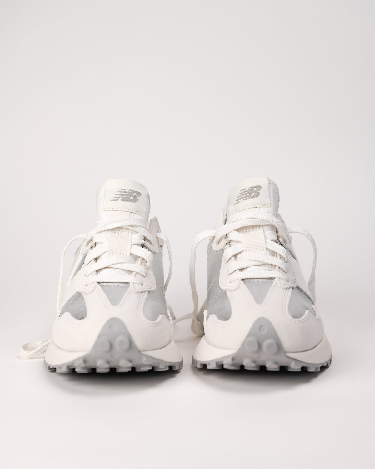 Front view of the New Balance 327 in metallic showing trail-inspired outsole and nylon tongue